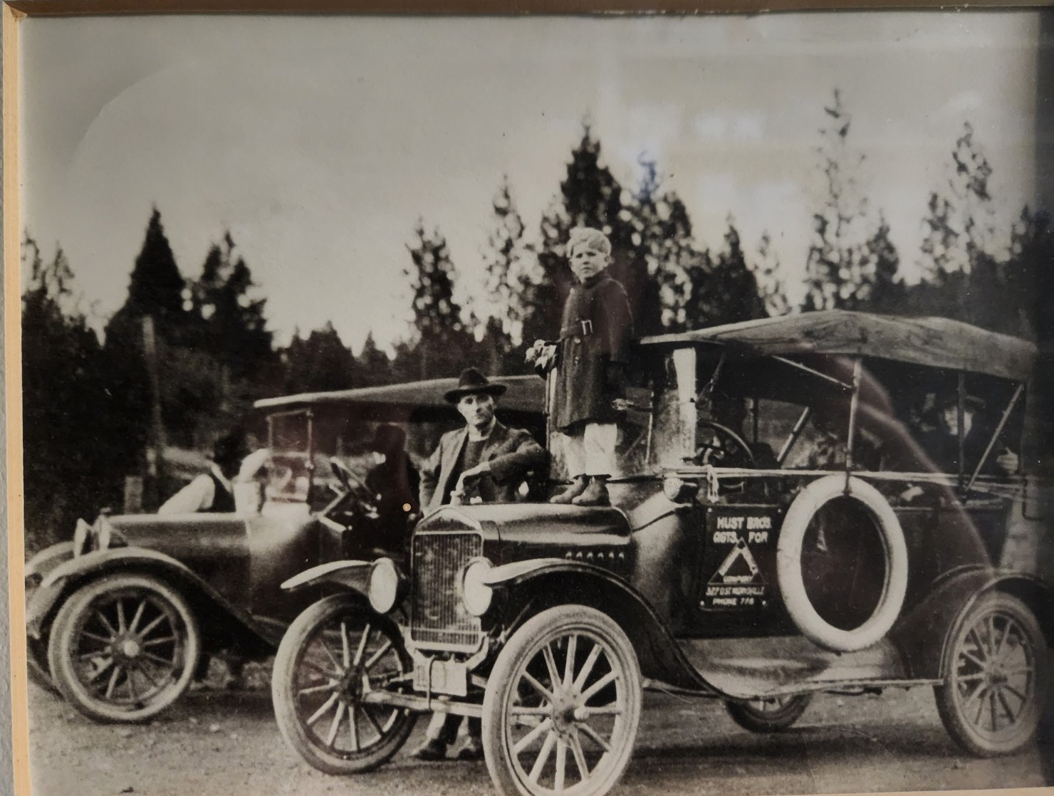 Historic 1920 photograph showing Bill Hust with early Hust Bros automobiles